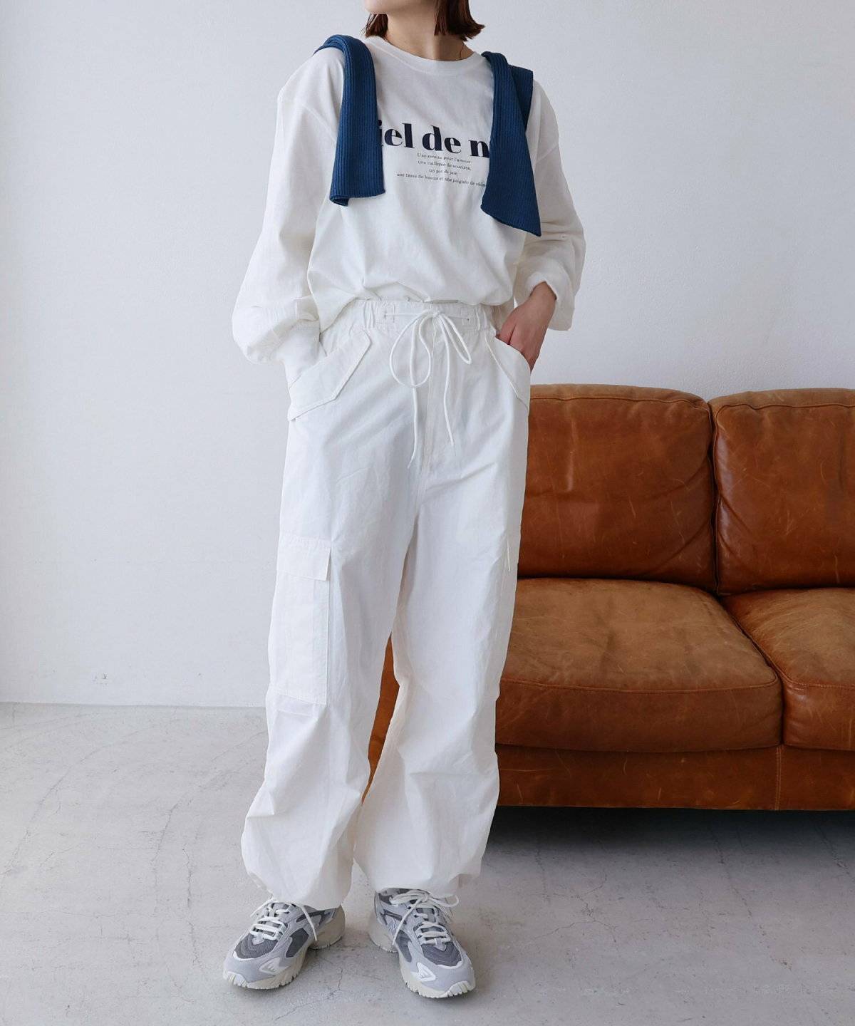 白トップスにベージュのパンツを穿いた女性