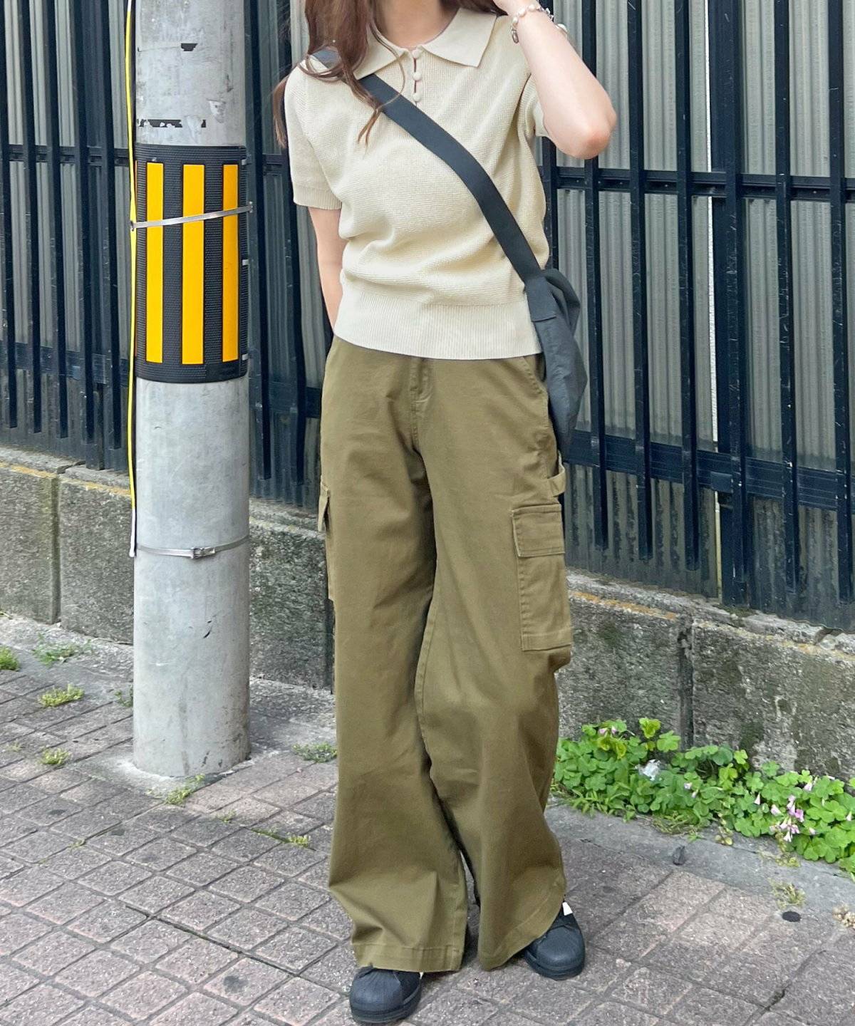 白ニットにグリーンのパンツを合わせた女性