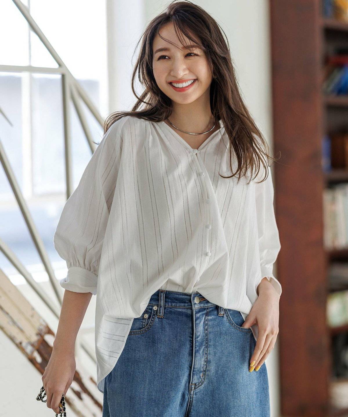 白トップスにデニムを合わせた女性