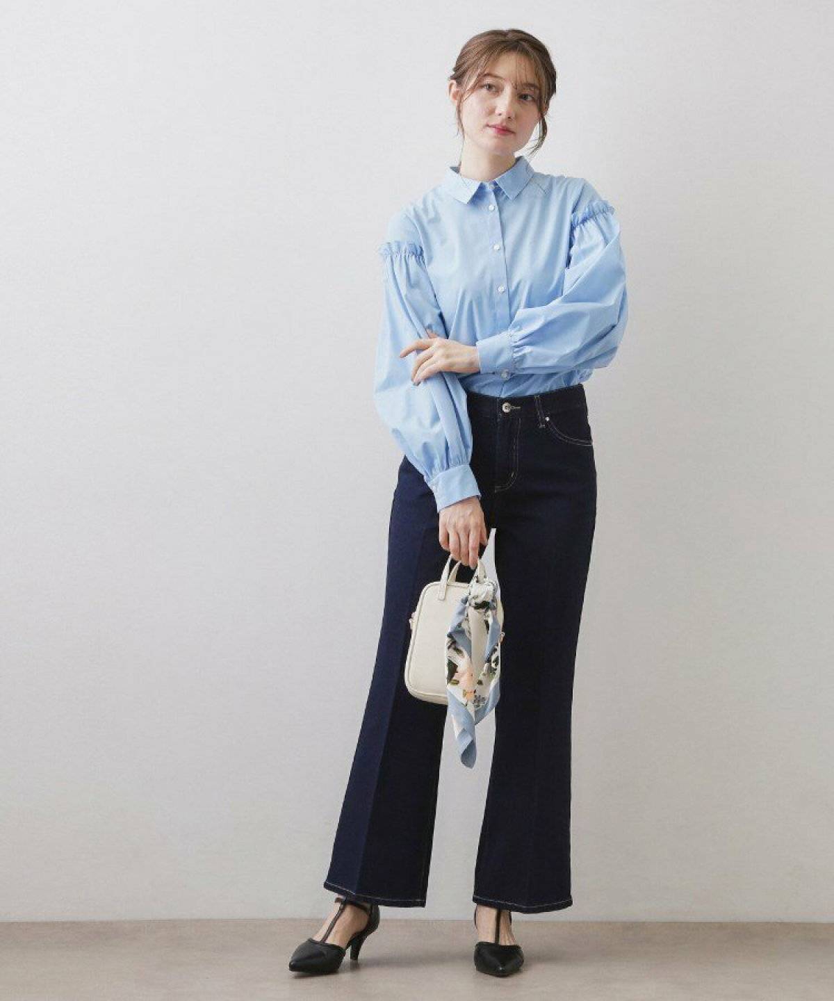 ブルーのブラウスにネイビーのパンツを合わせた女性