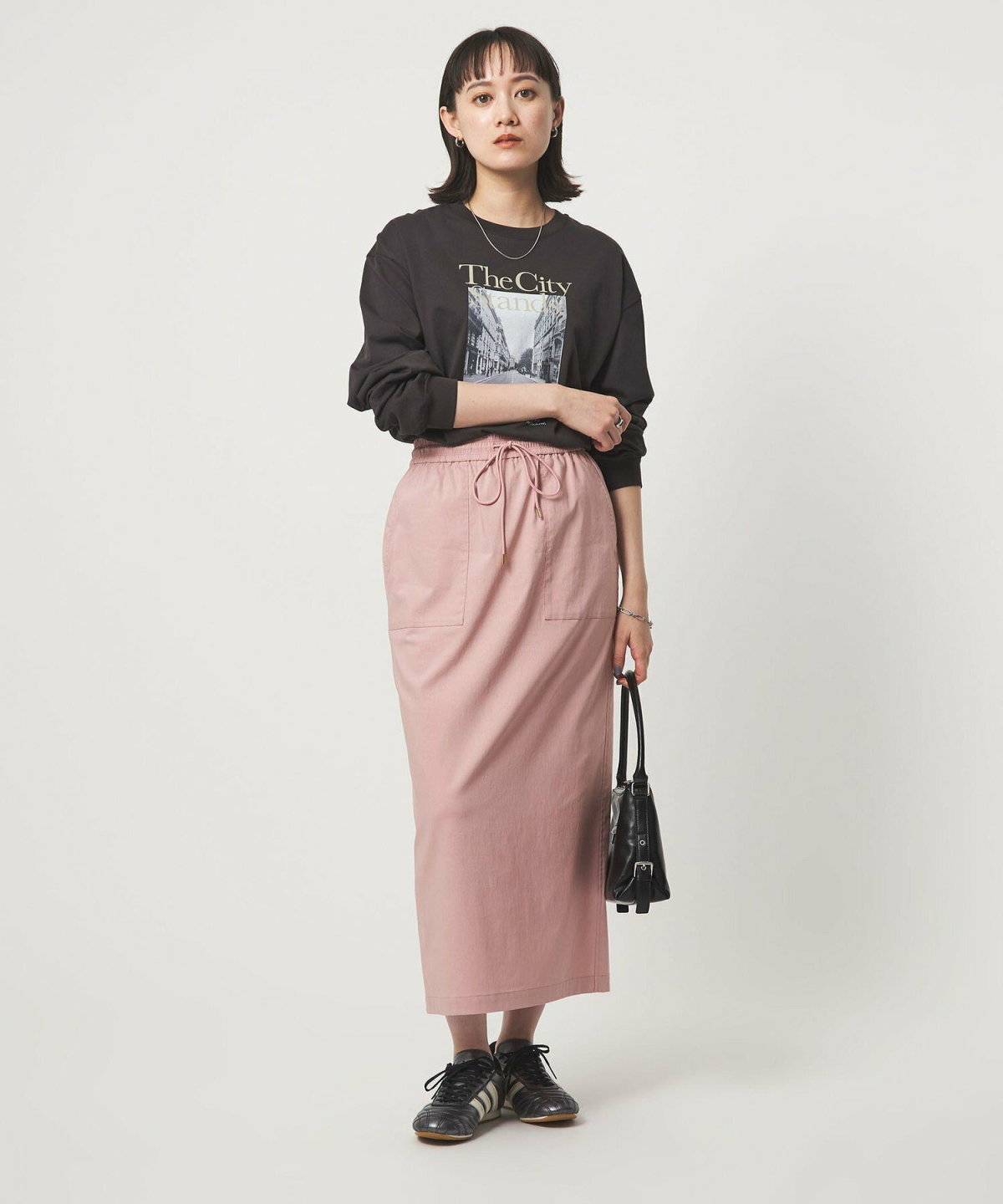 グレーのスウェットにピンクのスカートを合わせた女性