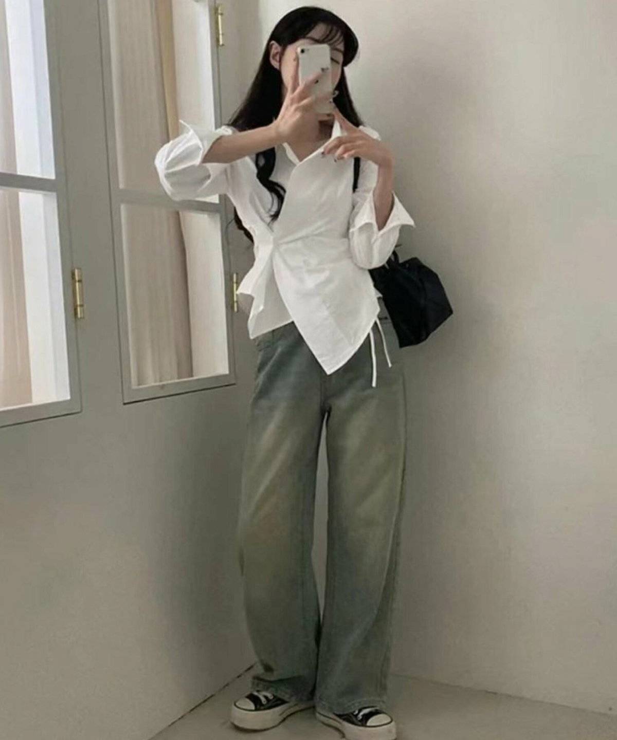 白ブラウスにデニムを合わせた女性