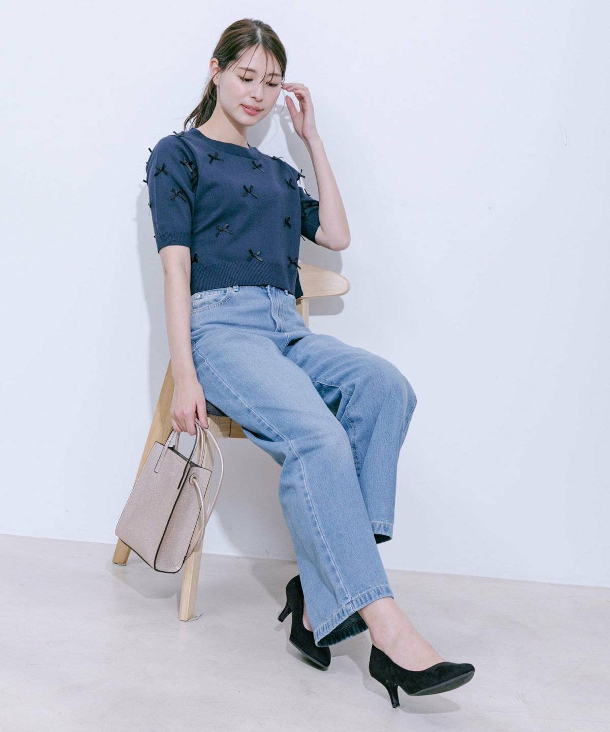 ネイビーのニットにデニムを合わせた女性