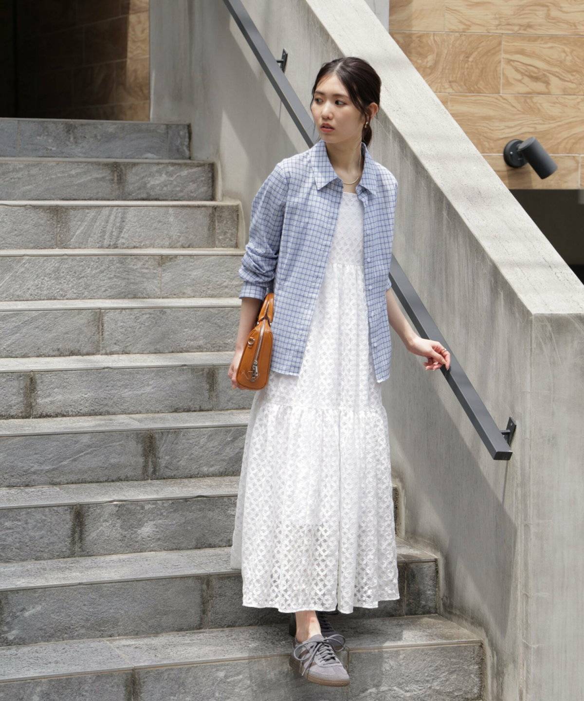 白ワンピースにブルーのシャツを羽織った女性