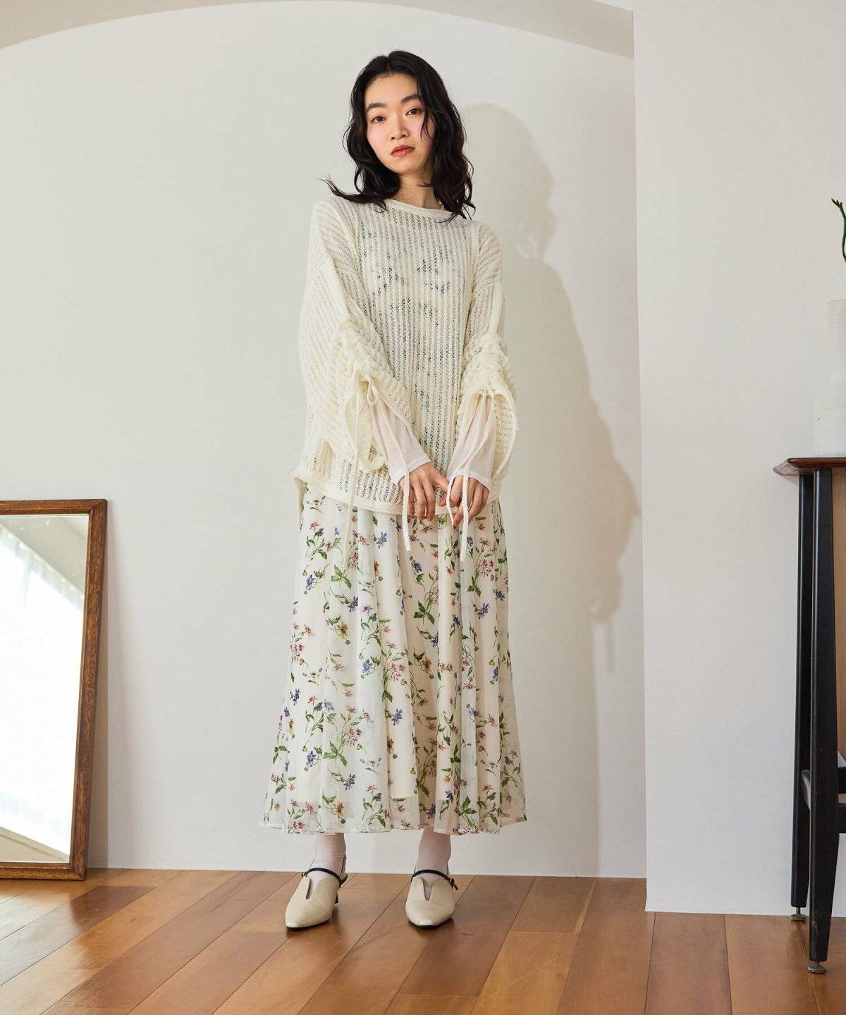 ワンピースに白のメッシュトップスを重ねた女性