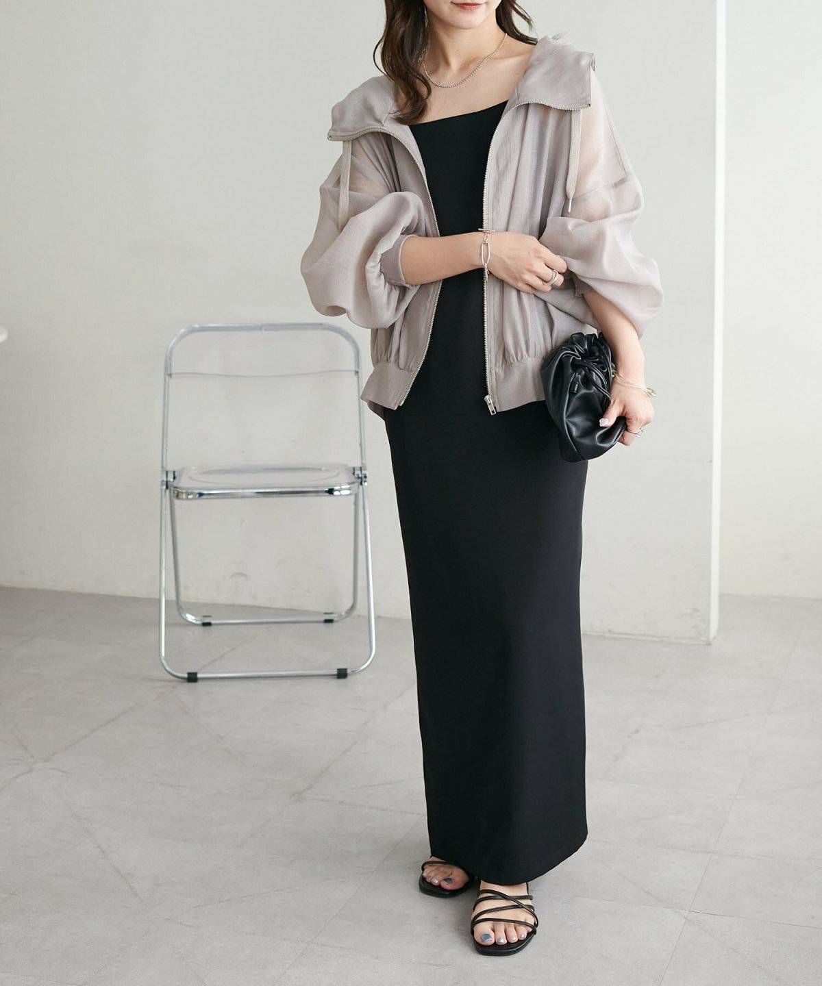 黒ワンピースにグレーのアノラックパーカーを重ねた女性