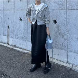  グレーのパーカーに黒スカートを合わせた女性 