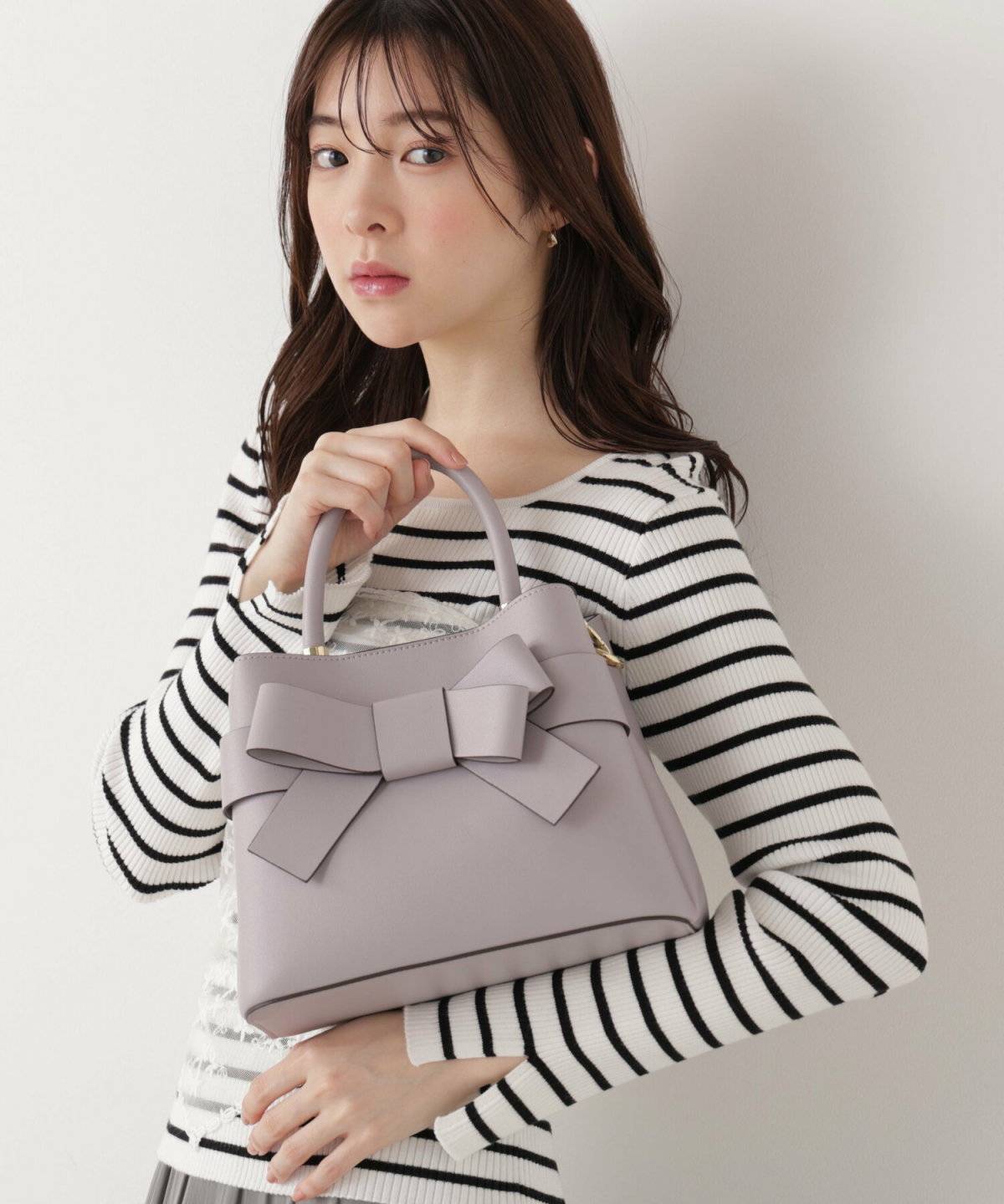 ラベンダーカラーのパンプスを履いた女性