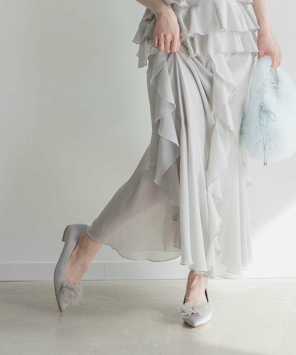 ラベンダーカラーのパンプスを履いた女性