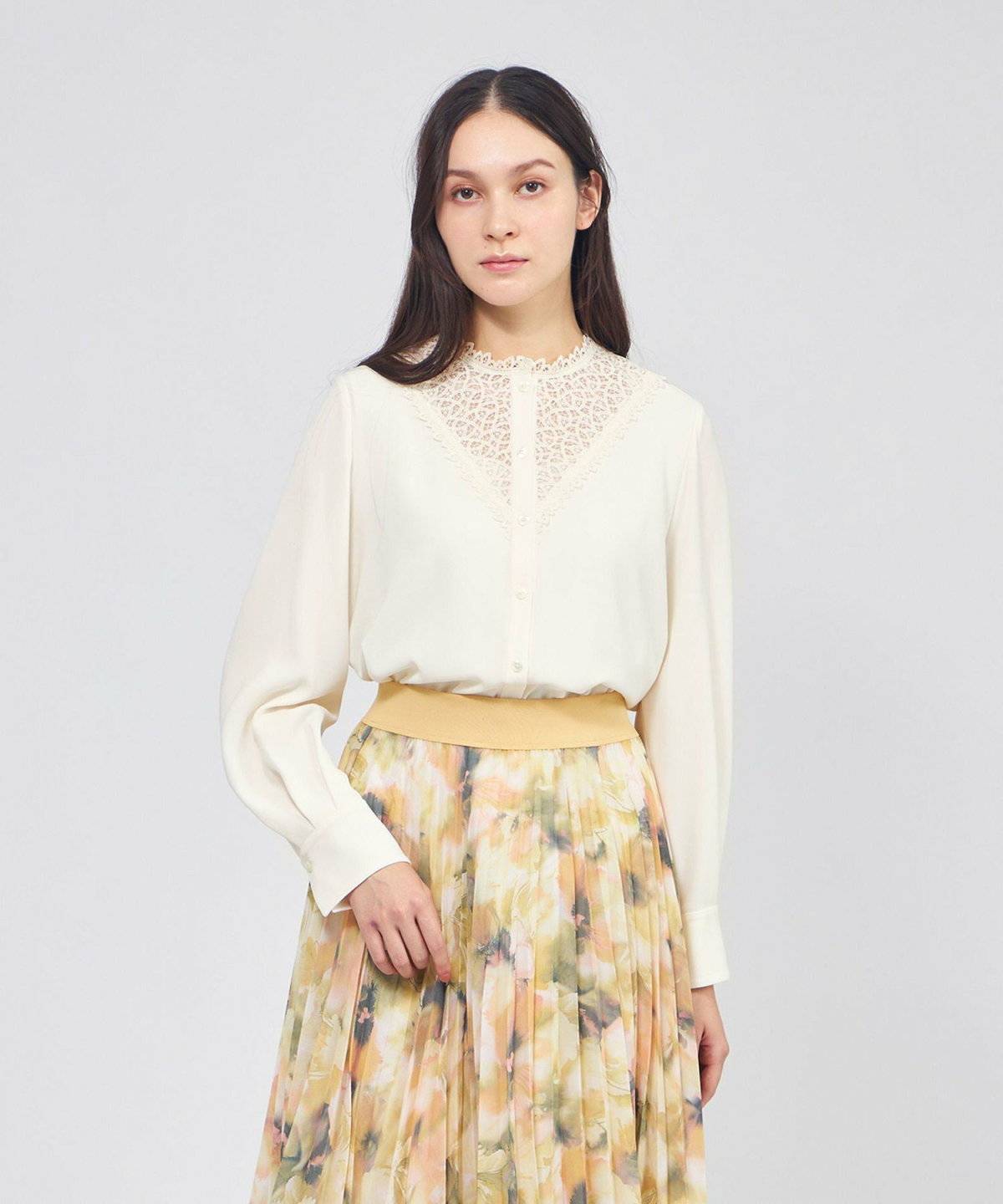 白ブラウスにベージュの花柄スカートを合わせた女性