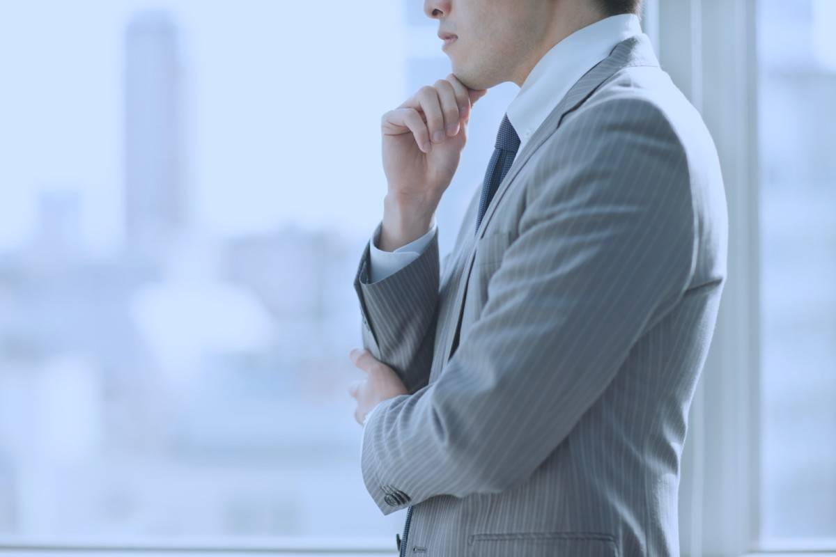 外を見ながら考える男性