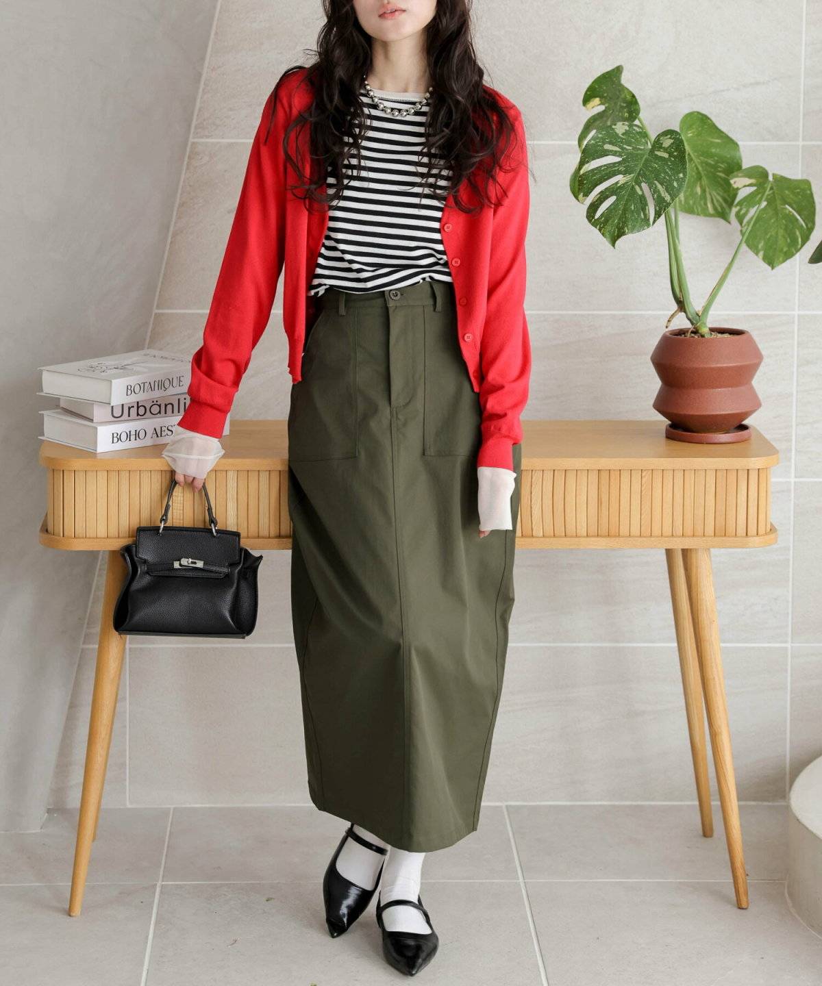 ミモレ丈カーキスカートを着用した女性