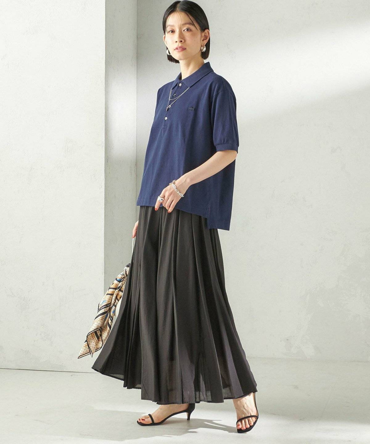 ポロシャツに黒スカートを合わせた女性