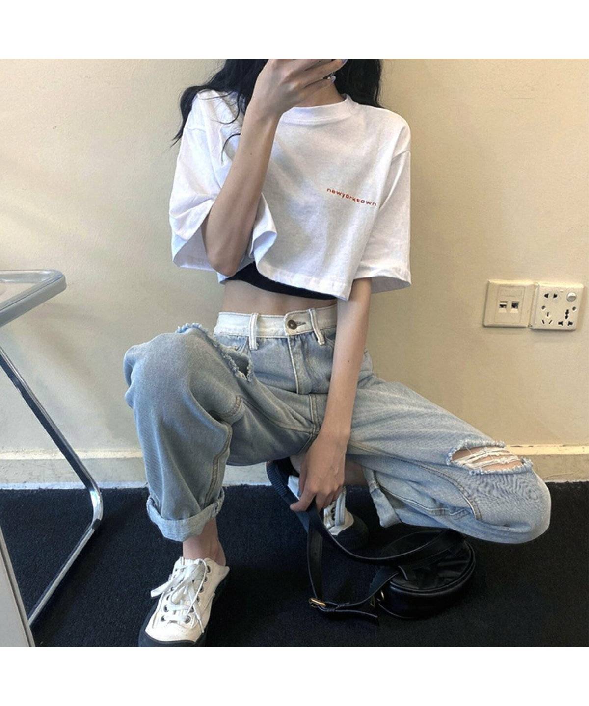 ホワイトのトップスにデニムを合わせた女性