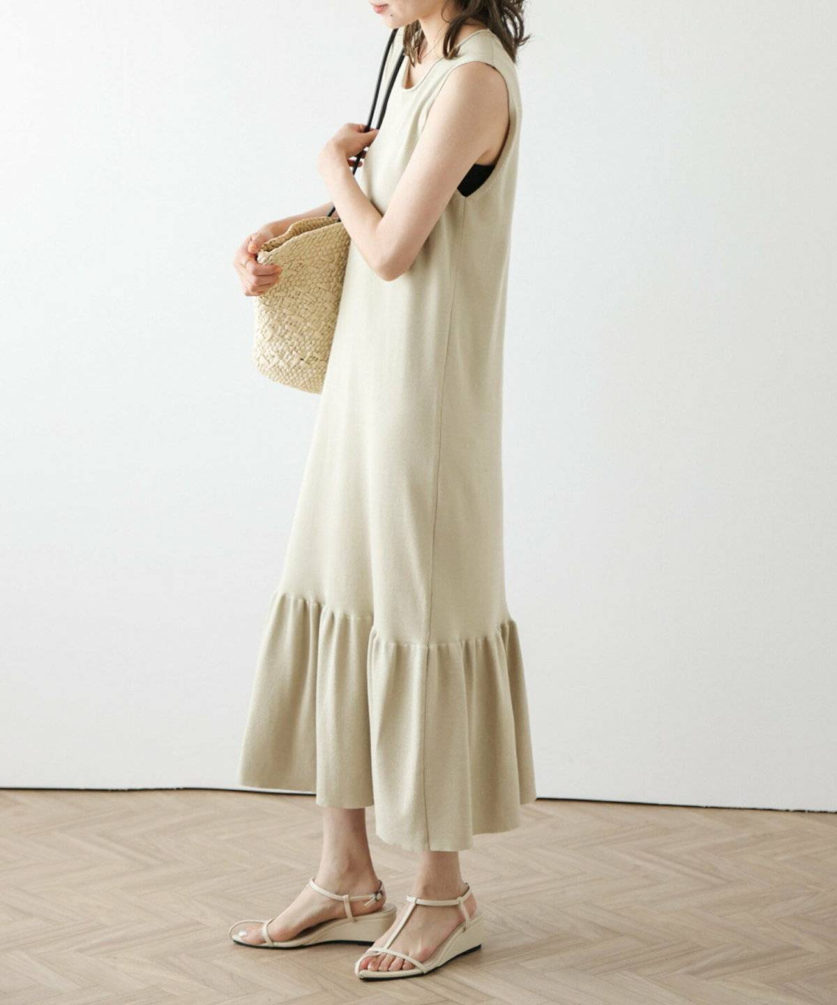 ブラウンのニットワンピースにデニムジャケットを肩掛けした女性