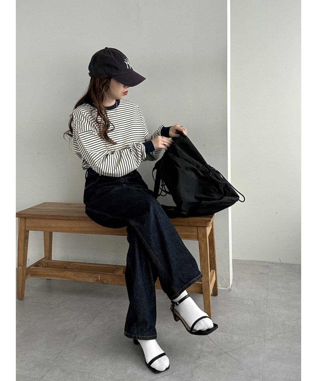 ボーダー柄のトップスにデニムを合わせた女性