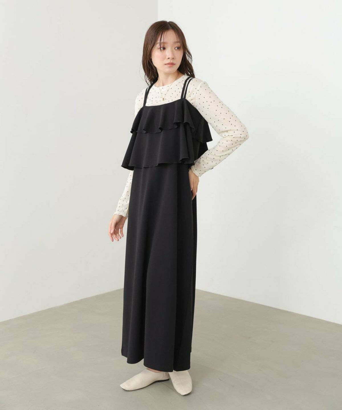 白ブラウスにブラウンのワンピースを合わせた女性