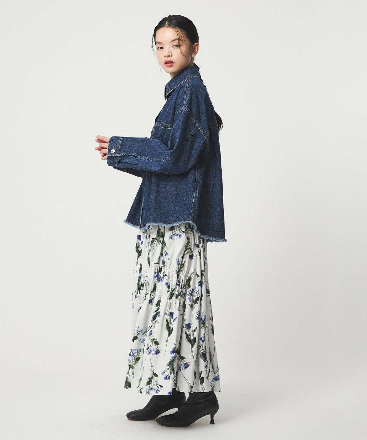 花柄ワンピースにデニムシャツを羽織った女性
