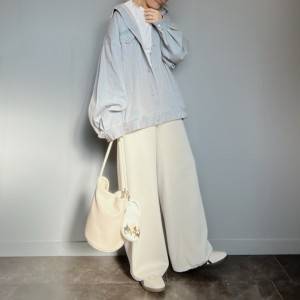  デニムジャケットに白パンツを合わせた女性 