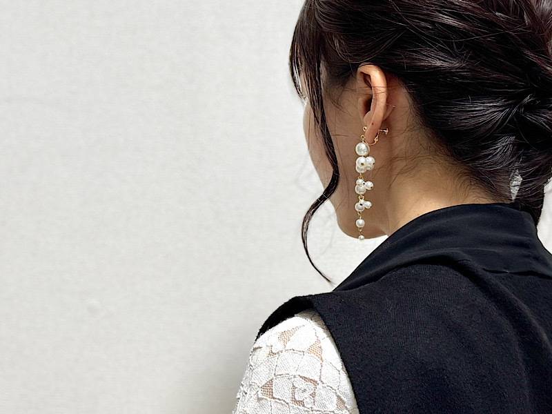 パールロングイヤリングをつけた女性の写真