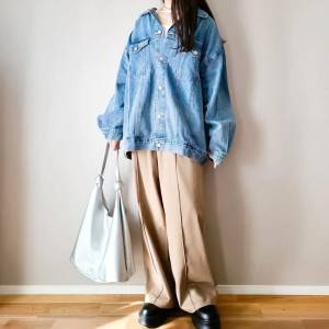  デニムジャケットにベージュパンツを合わせた女性 