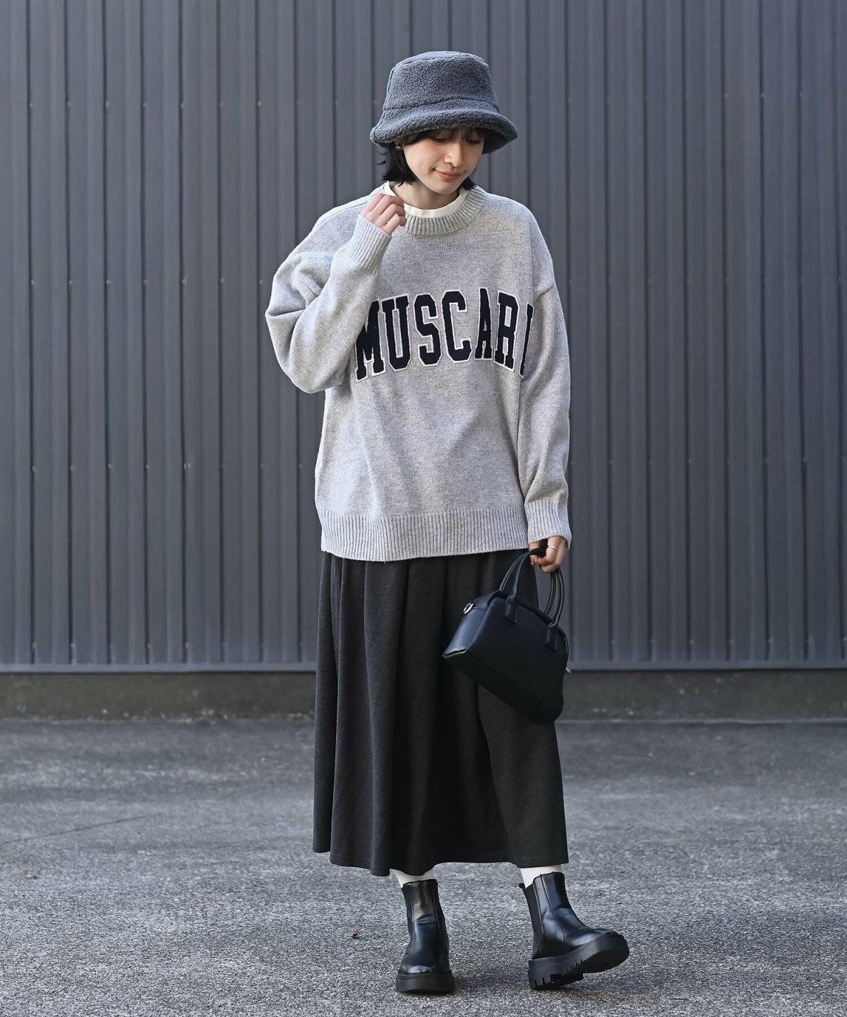 ブラウンのスウェットにベージュのスカートを合わせた女性