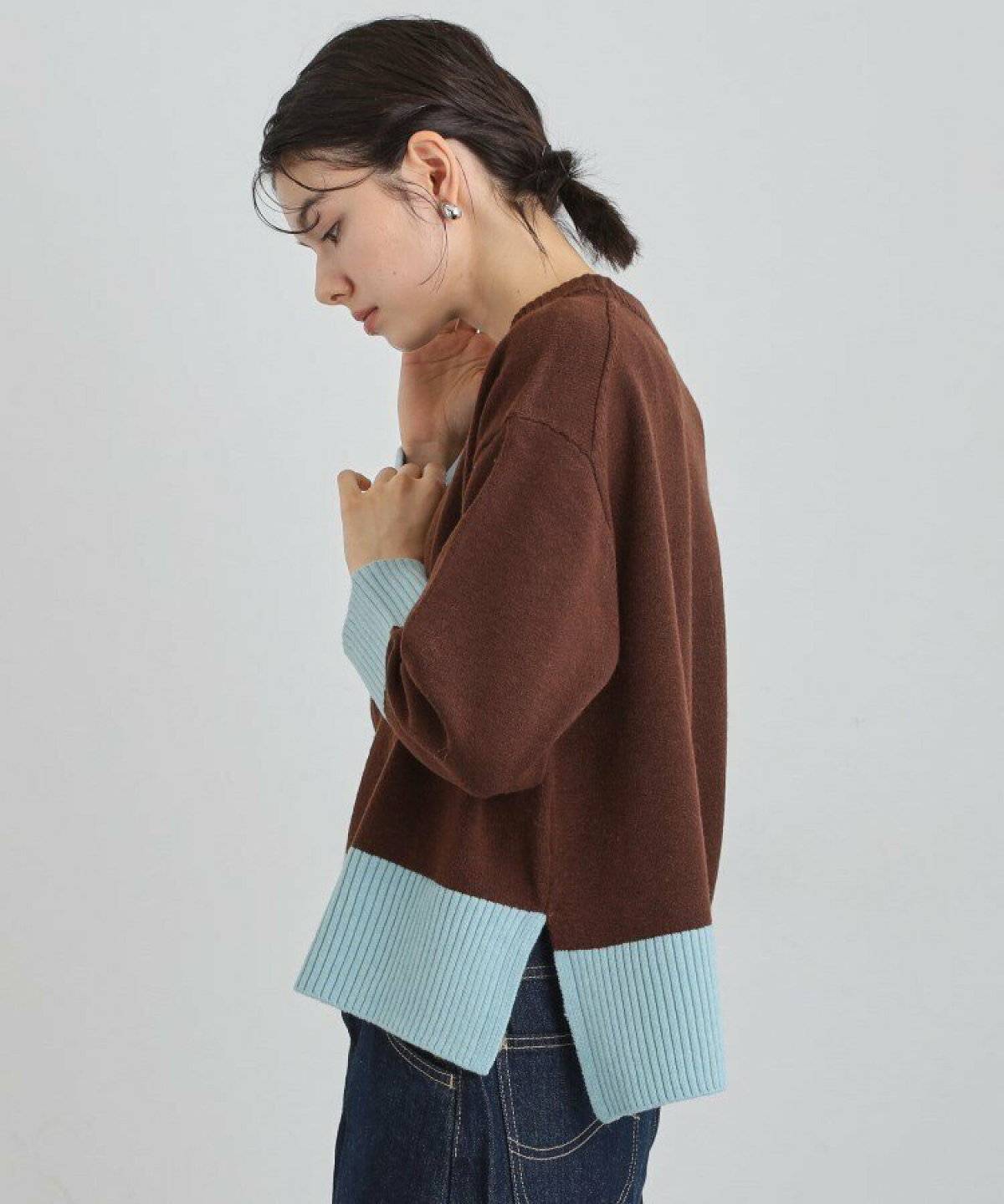 黒ニットにデニムを合わせた女性