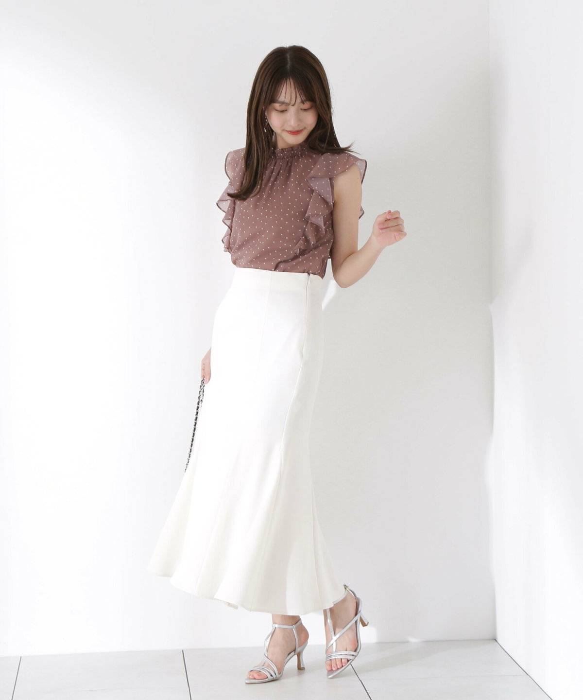 ドット柄ブラウスにマーメイドスカートを合わせた女性