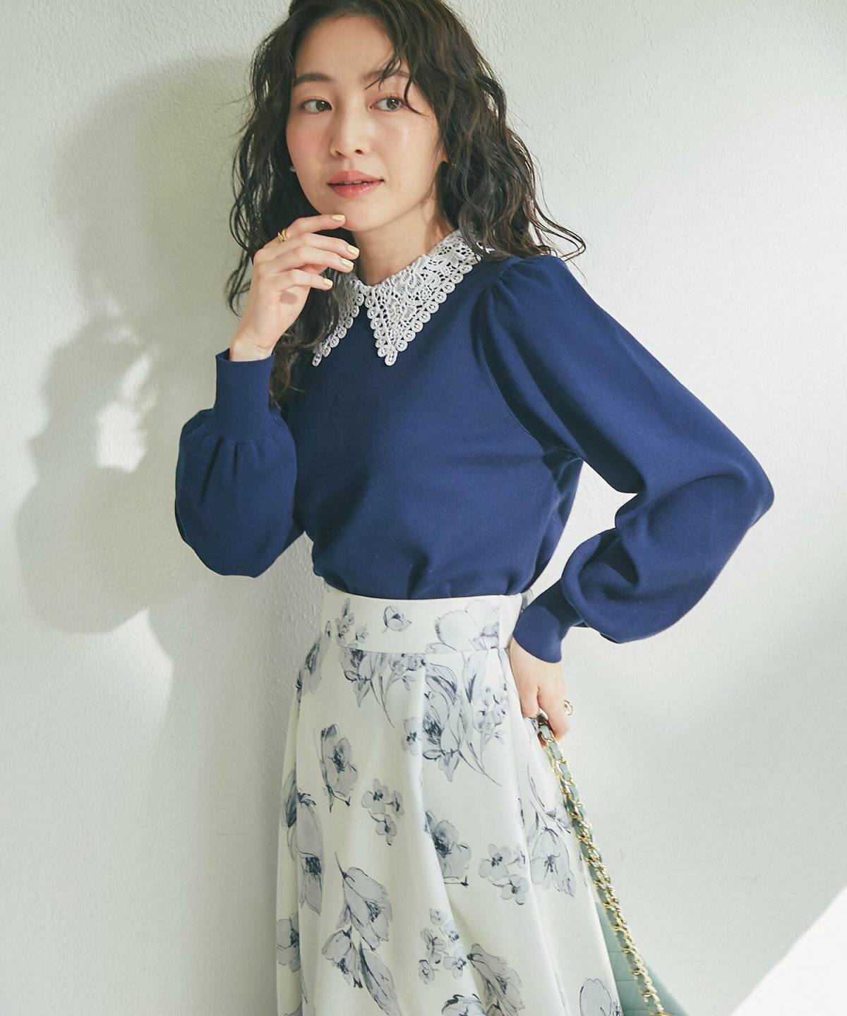 白ブラウスに花柄スカートを合わせた女性