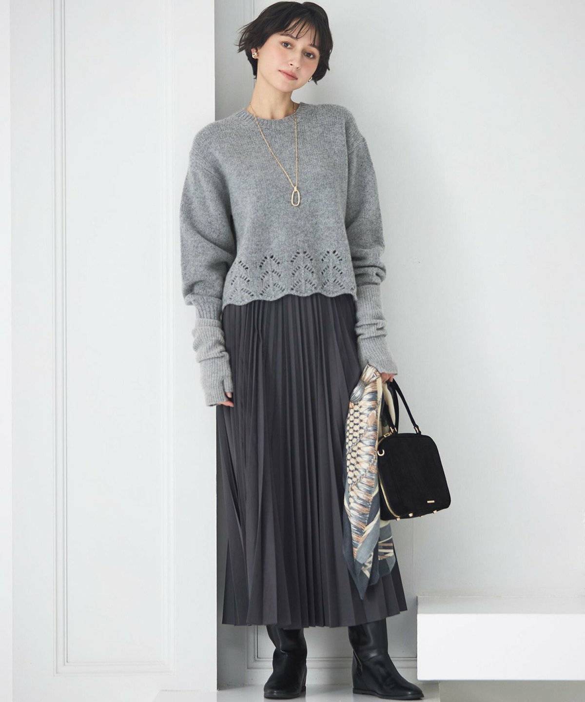 グレーのニットにスカートを合わせた女性