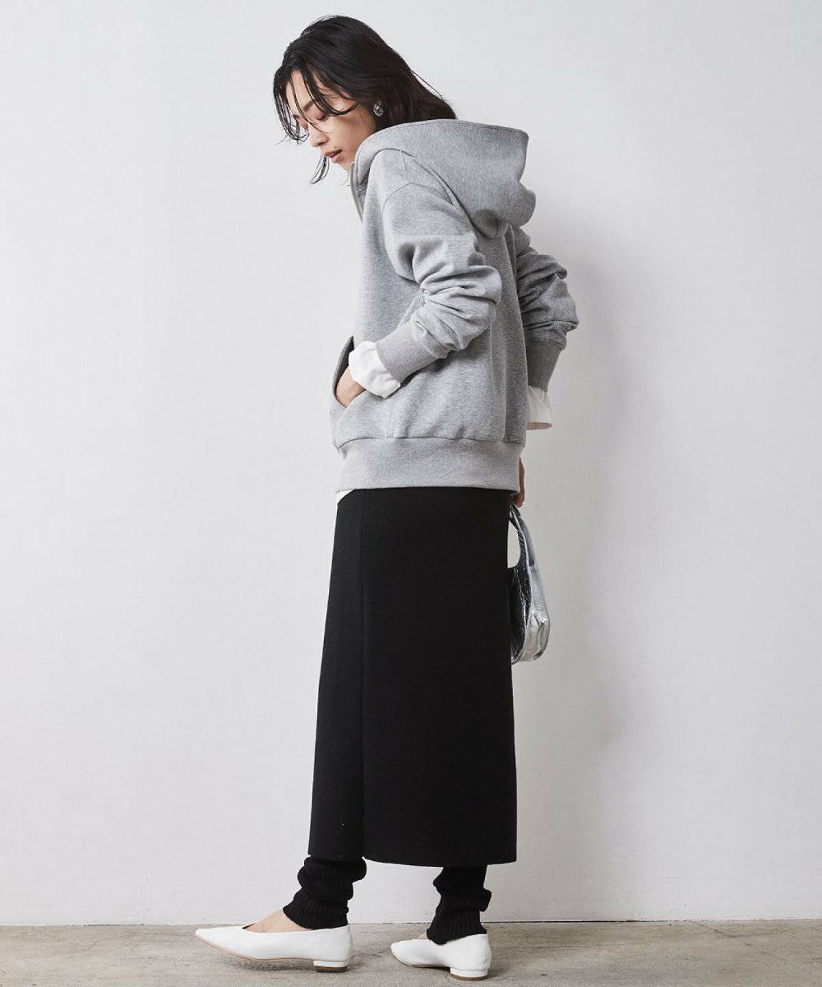 黒パーカーにチェック柄スカートを合わせた女性