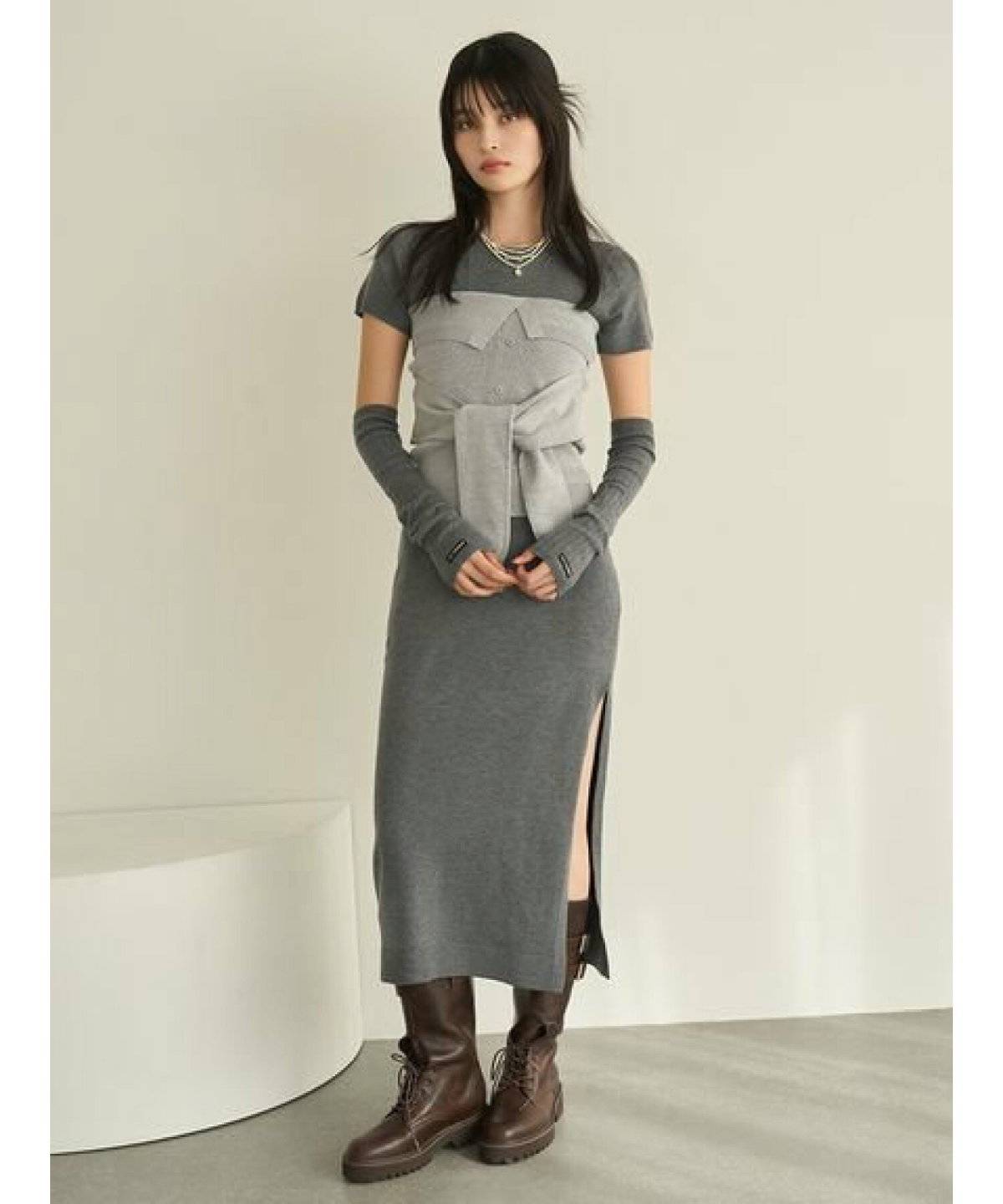 白ワンピースにブルーニットを重ねた女性