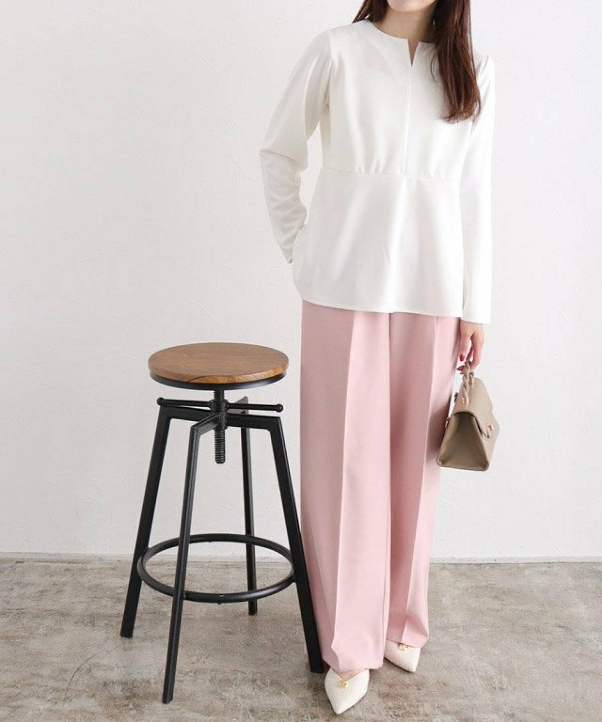 ベージュのスウェットにピンクのパンツを合わせた女性