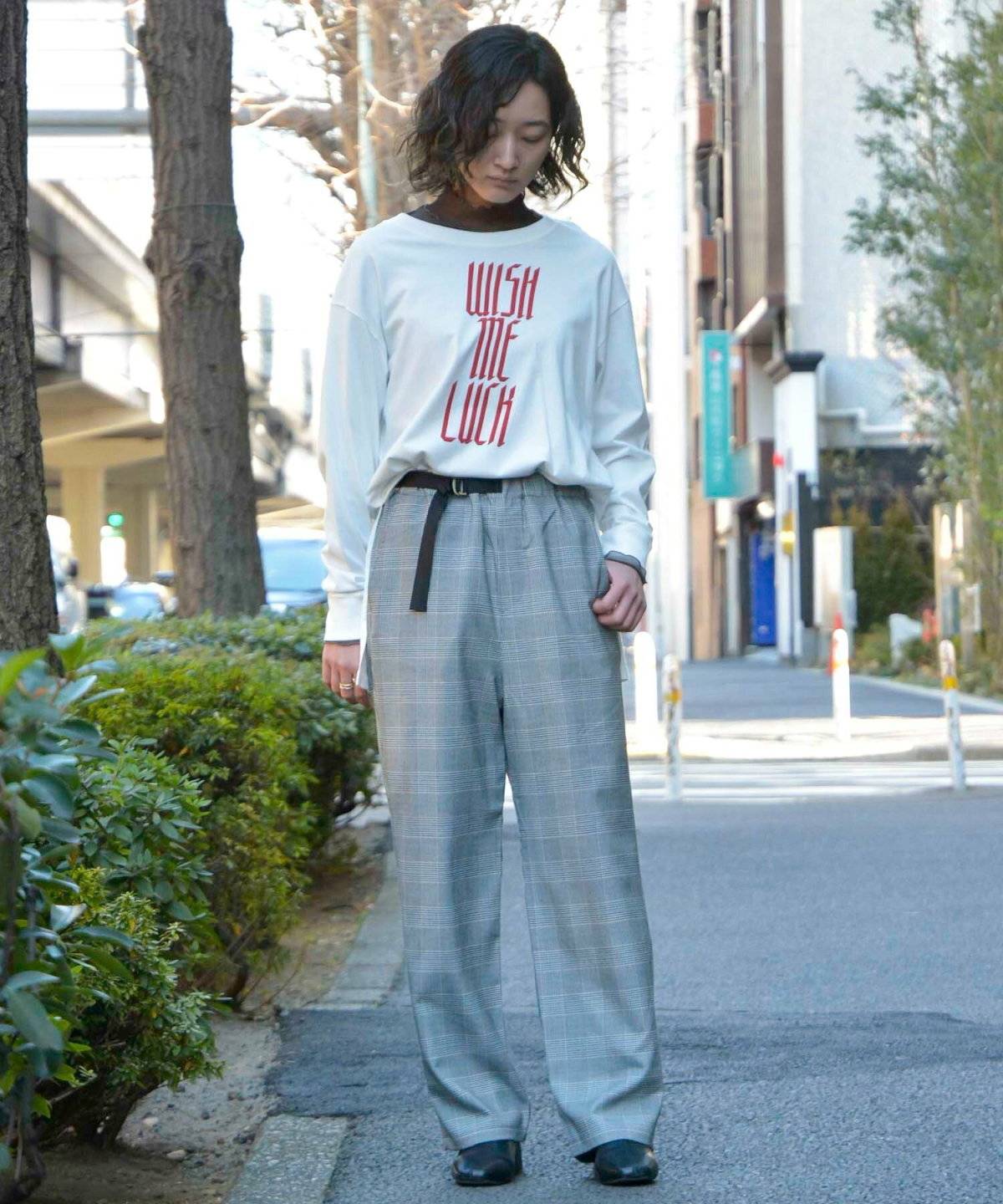 グレーのパーカーにチェック柄パンツを合わせた女性