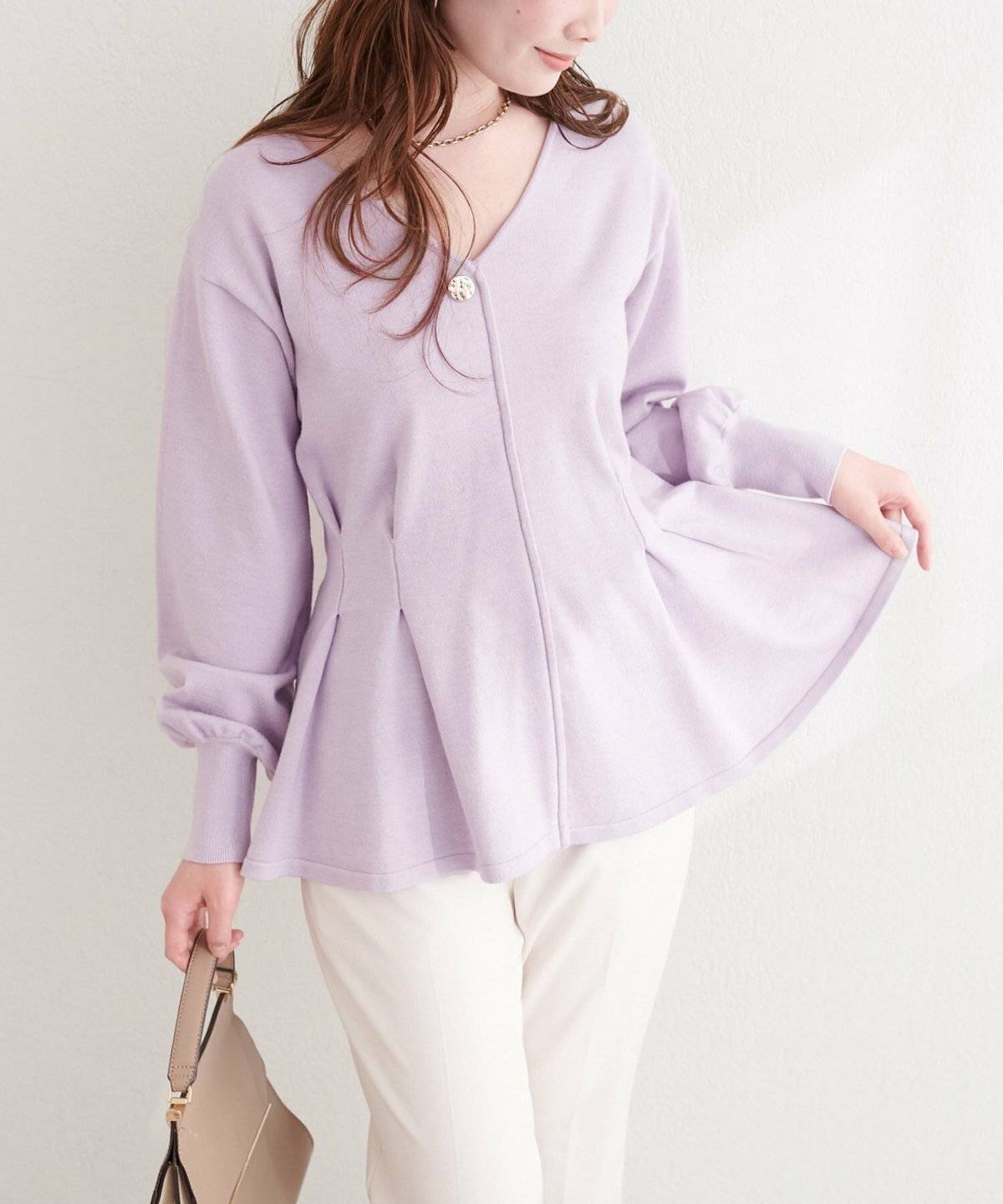 パープルのニットに白デニムを合わせた女性