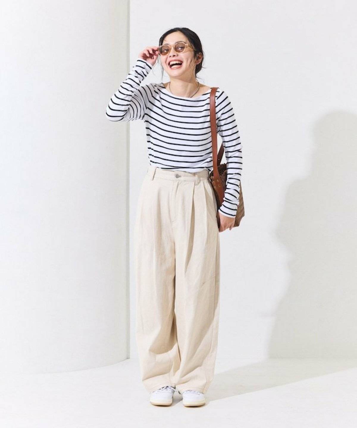 ボーダー柄トップスに白パンツを合わせた女性