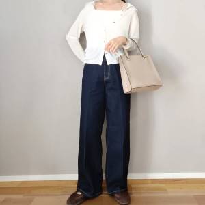  白トップスにデニムパンツを合わせた女性 
