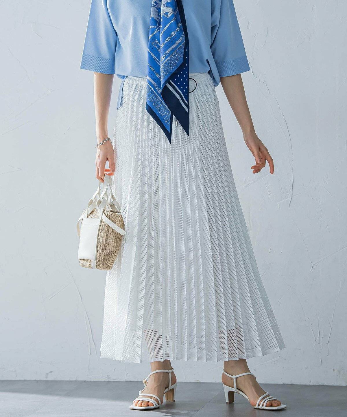Tシャツに白のプリーツスカートを合わせた女性