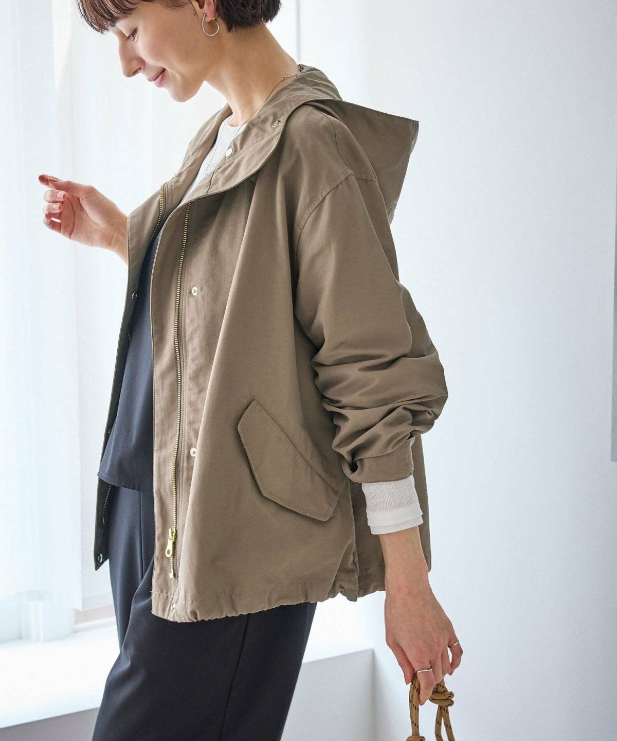 黒のレインコートで傘を持つ女性