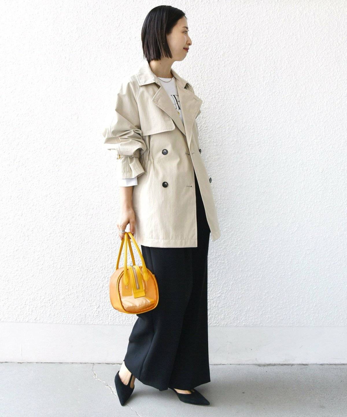 ミモレ丈のプリーツスカートの女性