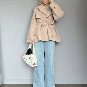  トレンチコートにデニムパンツを合わせた女性 
