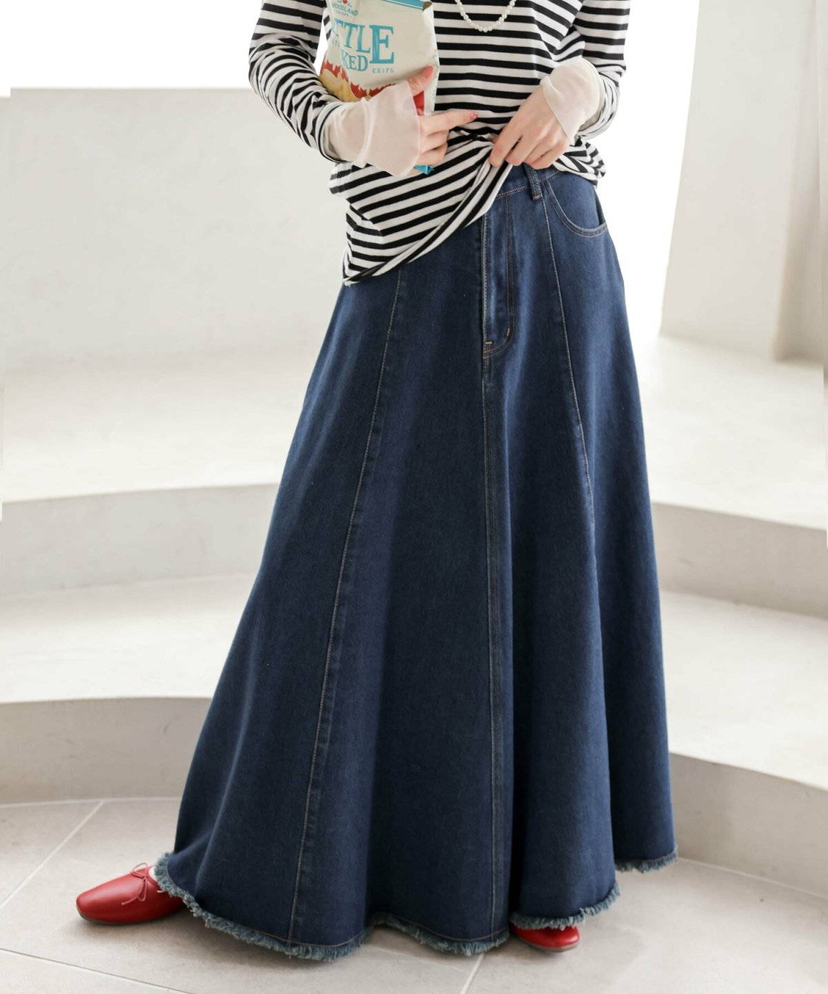 トラックジャケットにデニムスカートを合わせた女性