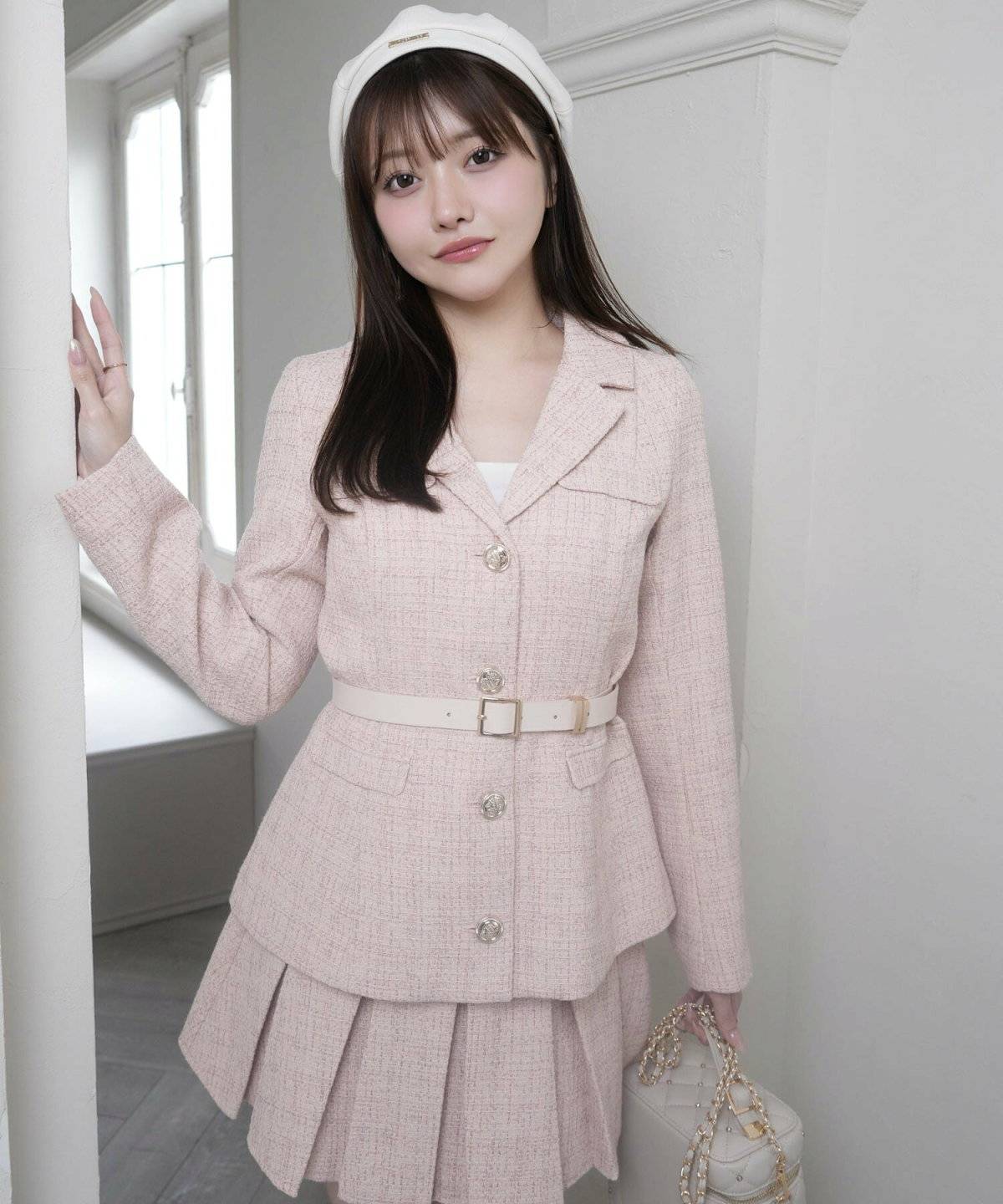 ピンクのセットアップに白のインナーを重ねた女性