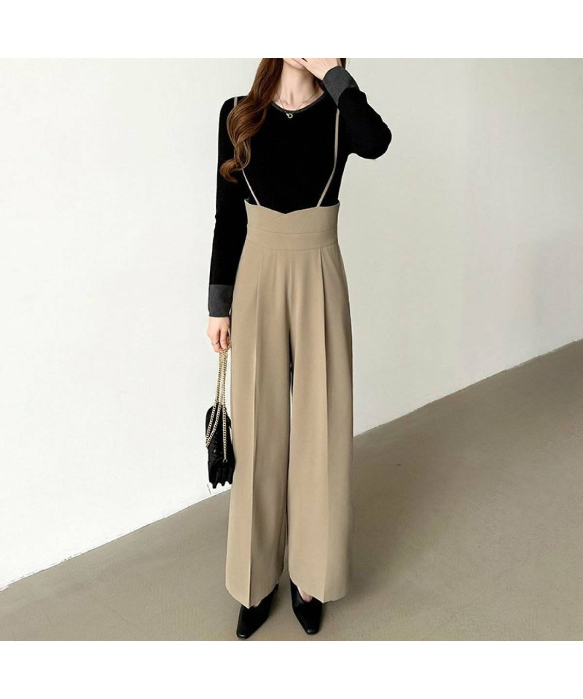 黒トップスにブラウンのサロペットパンツを合わせた女性