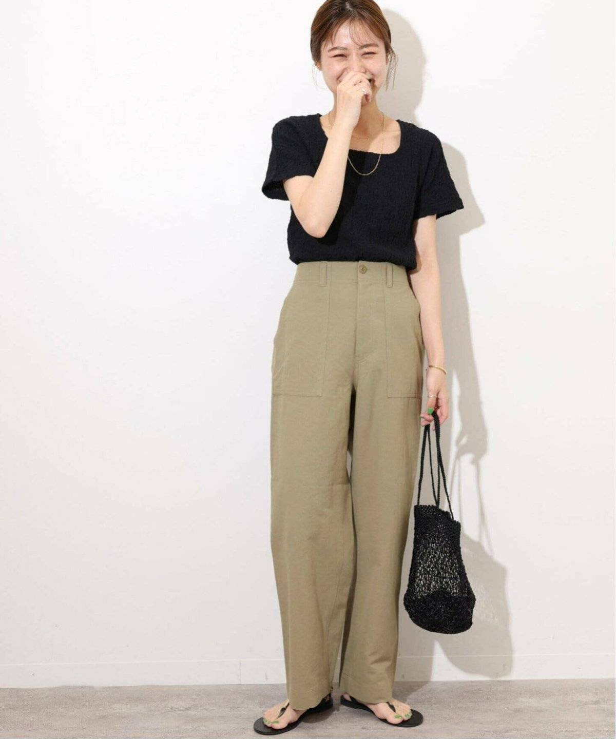 黒ニットにカーゴパンツを合わせた女性
