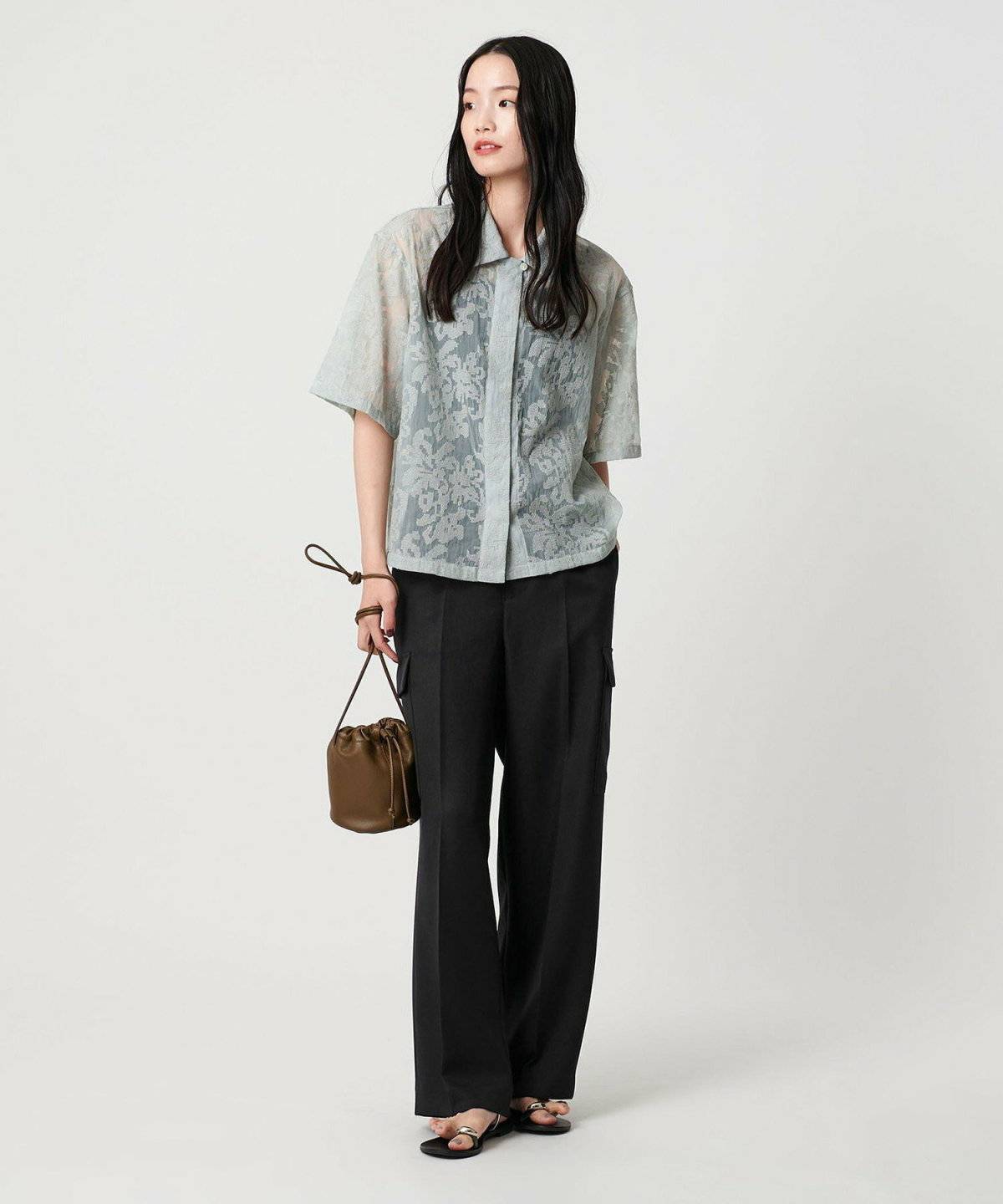 グレーのニットに黒のカーゴパンツを合わせた女性