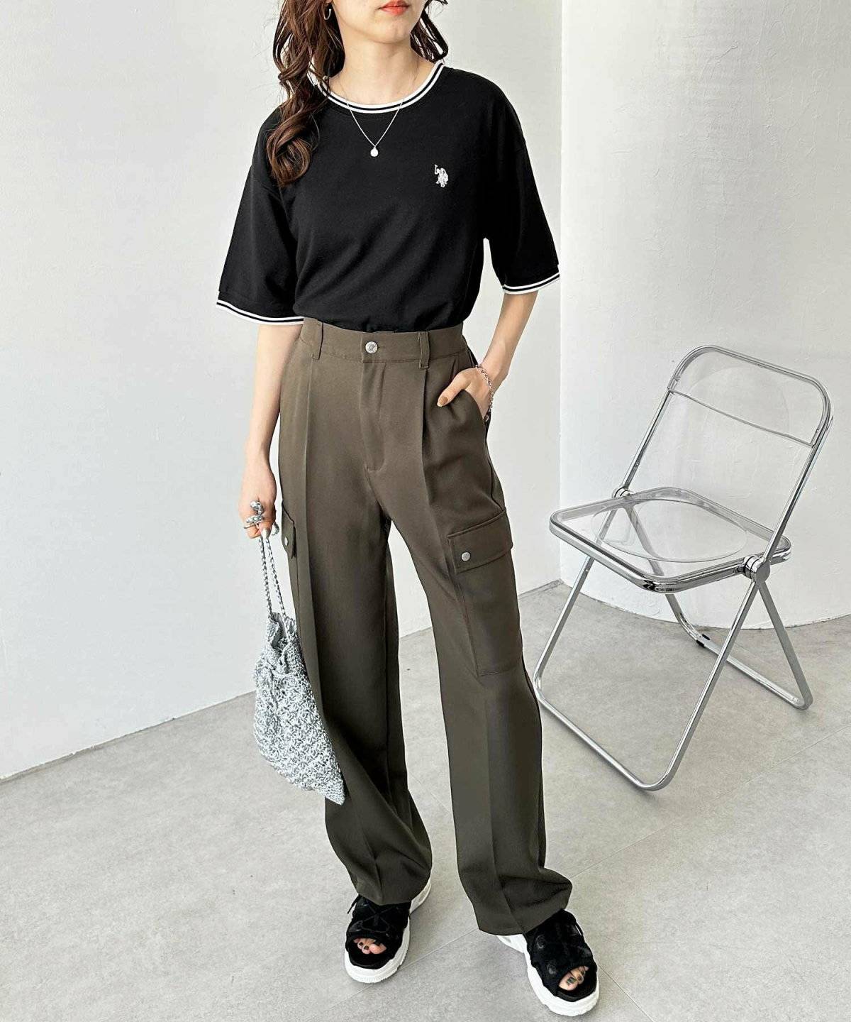 黒のポロシャツにカーゴパンツを合わせた女性