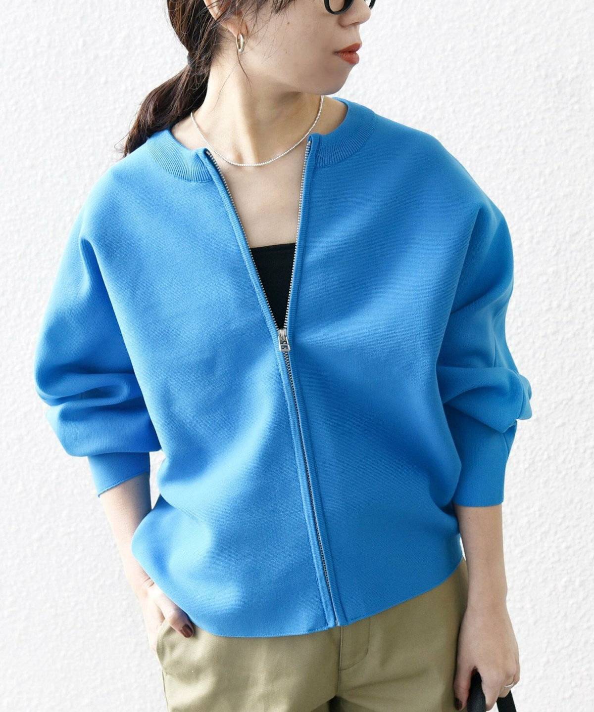 カーディガンにイエローのパンツを合わせた女性