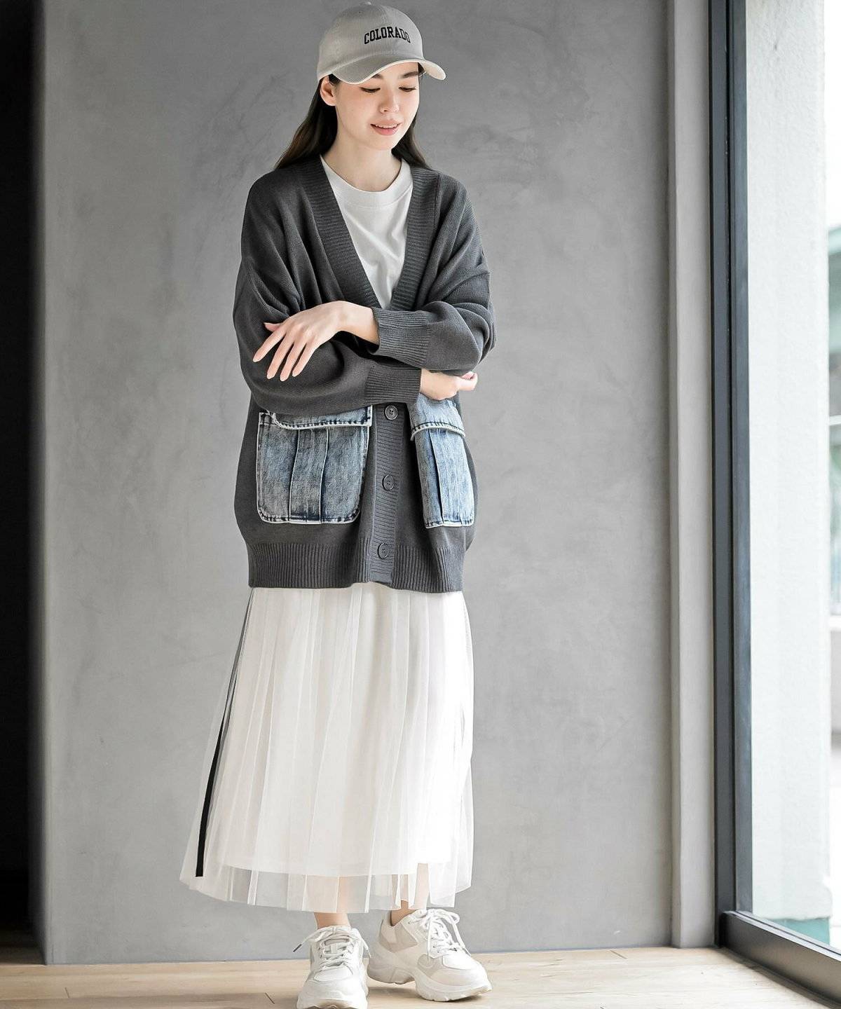 白ワンピースにグレーのカーディガンを羽織った女性