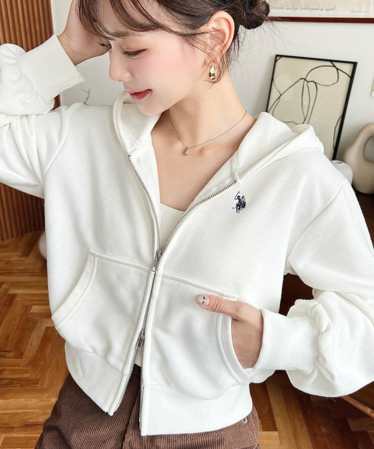 白パーカーにベージュのパンツを合わせた女性